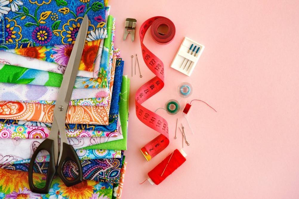 Handnähmaschine-Test: verschiedene Stoffe inkl. Zubehör liegen auf einer Fläche.