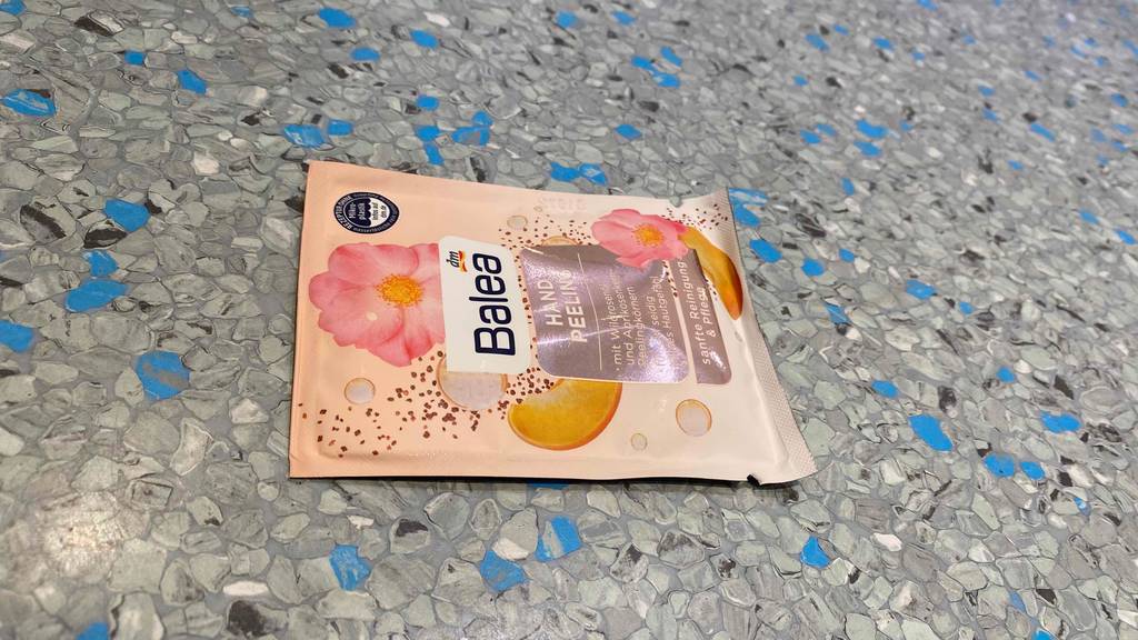 Handpeeling-Test: Verpackung von Handpeeling liegt aufgrauem Untergrund