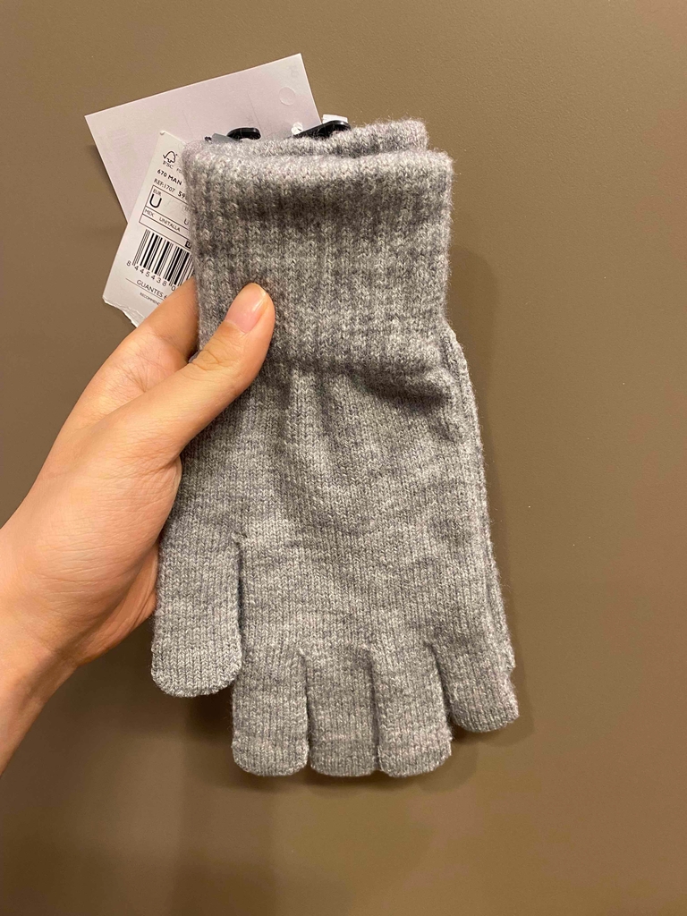 Handschuhe-Damen-Test: graue Handschuhe werden in der Hand gehalten.