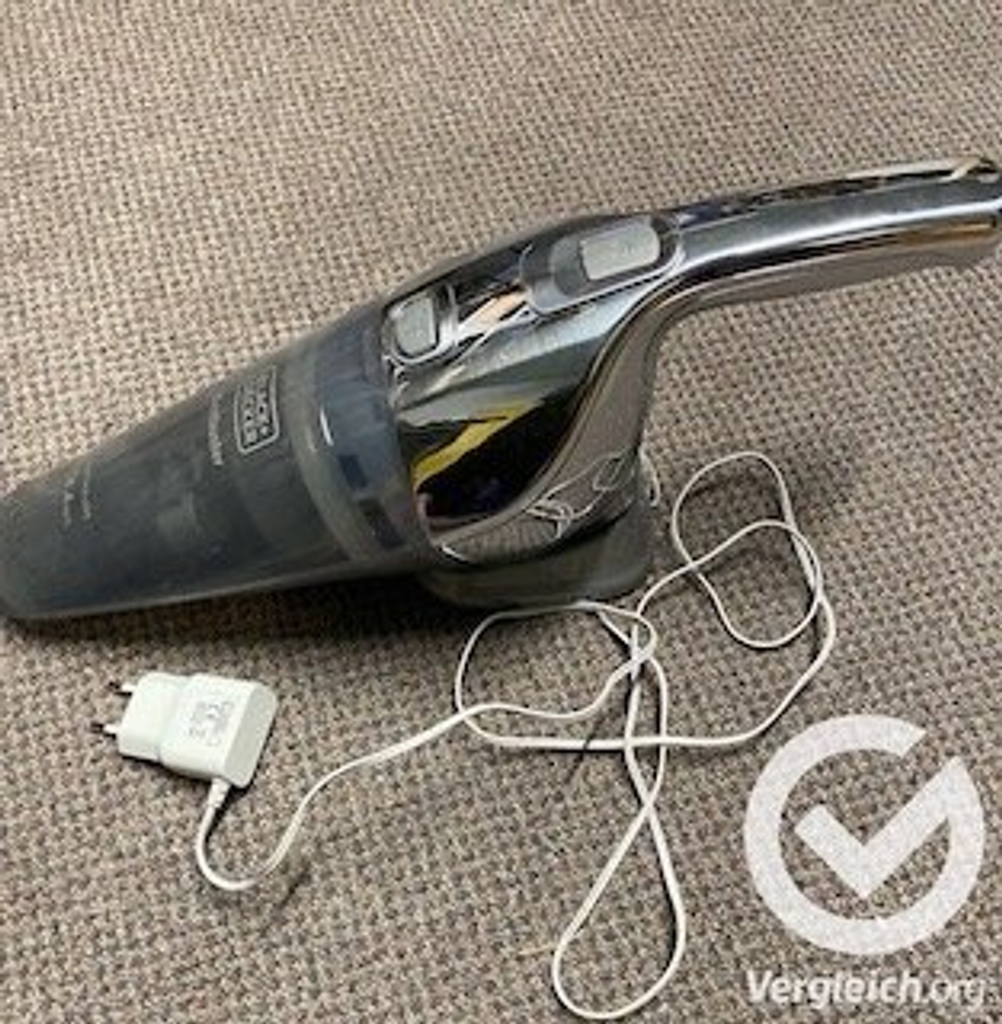 Handstaubsauger mit Kabel auf einem schönen Teppich.