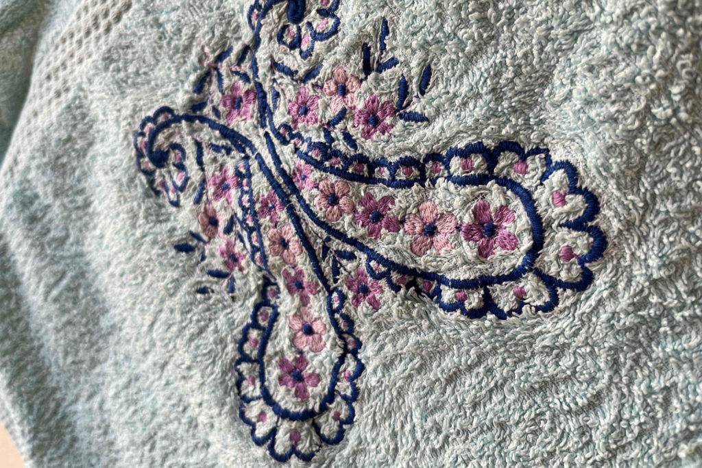 Handtücher im Test: Detailansicht einer schmetterlingsähnlichen Stickerei.