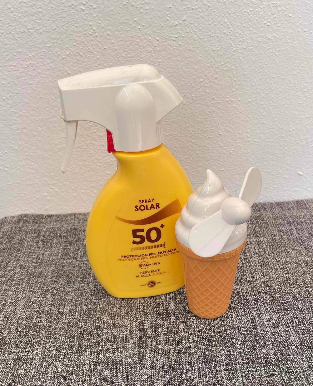 Getesteter Handventilator im Eiscreme-Design befindet sich neben einer Sonnencreme. 