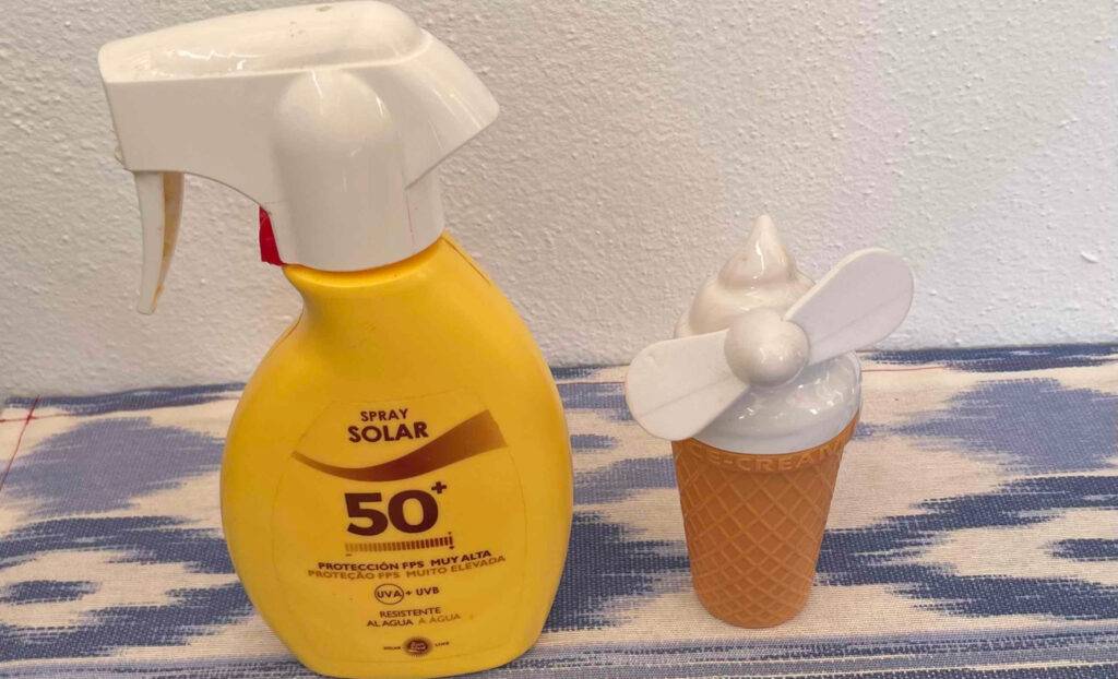 Neben einem Spender mit Sonnencreme steht ein getesteter Handventilator im Eishörnchen-Design.