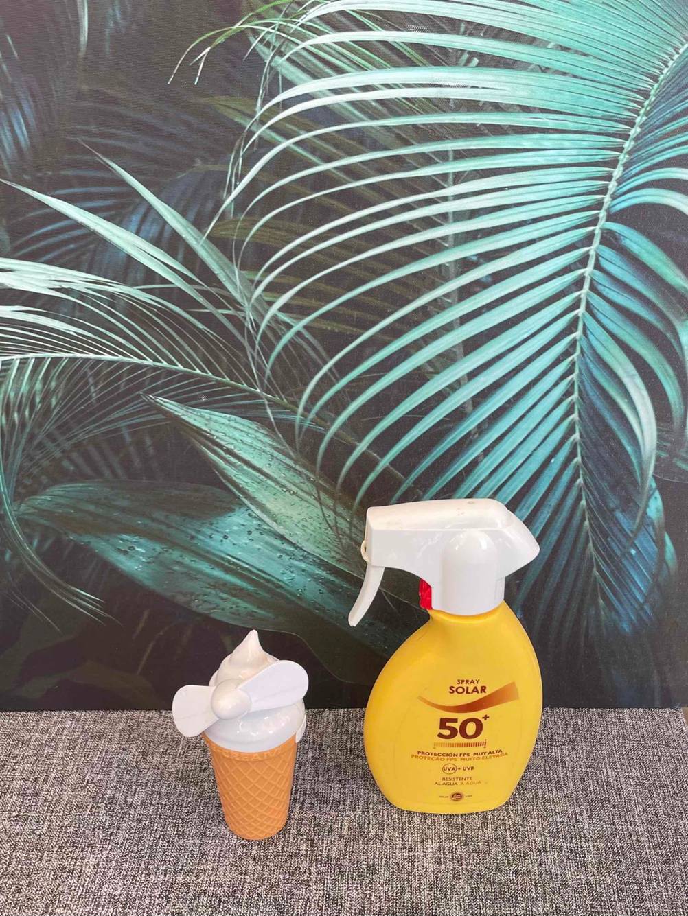 Getesteter Handventilator im Eiscreme-Design befindet sich neben einer Sonnencreme. 
