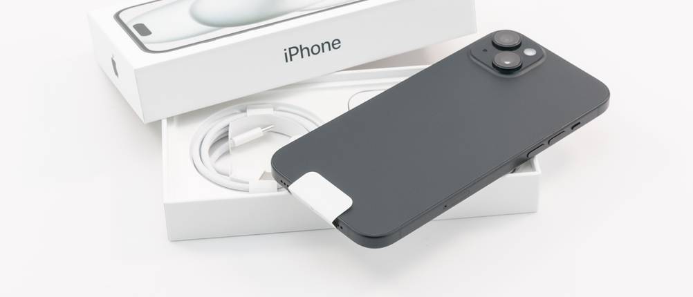 Test verschiedener Anbieter zum Handy verkaufen: Ein iPhone liegt inklusive Verpackung und Lightning-Kabel auf einem weißen Untergrund.