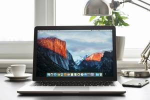 Anbieter zum Handy verkaufen im Test: Ein Apple MacBook steht auf einem Tisch, im Hintergrund ist ein Fenster zu sehen.