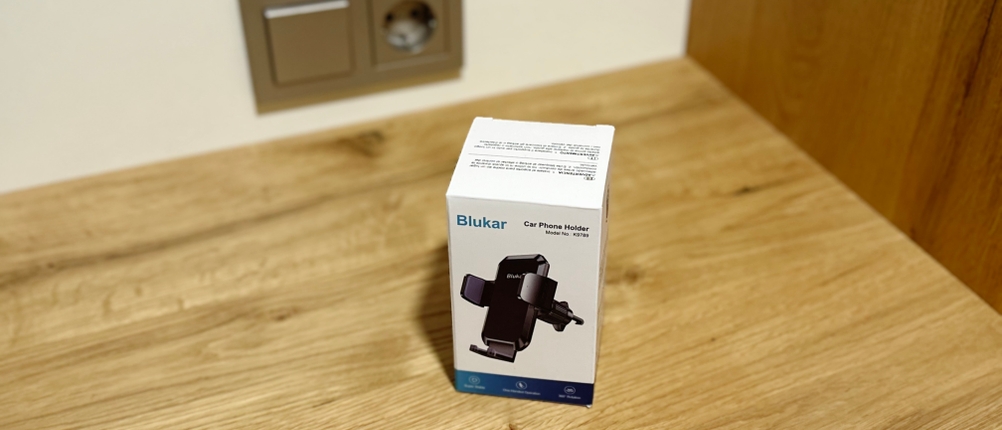 Die Auto-Handyhalterung von Blukar steht eingepackt auf einem Holztisch.