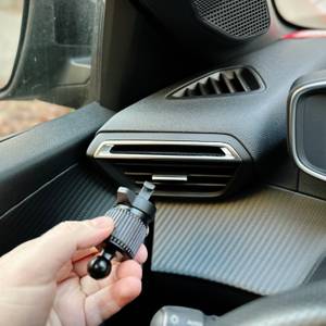 Die Auto-Handyhalterung von Blukar wird vor die Lüftung eines Autos gehalten.