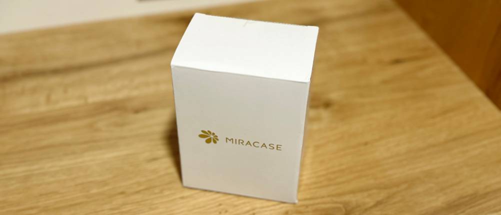 Die Auto-Handyhalterung von Miracase steht eingepackt auf einem Holztisch.
