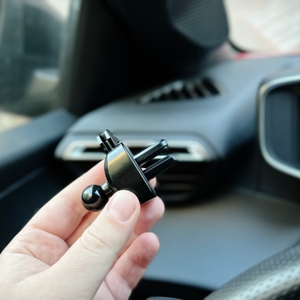 Die Auto-Handyhalterung von Vanmass wird vor der Lüftung eines Autos hochgehalten.