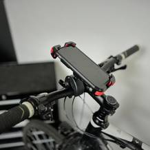 Die Handyhalterung von Lamicall mit Handy darin an einem Fahrrad.