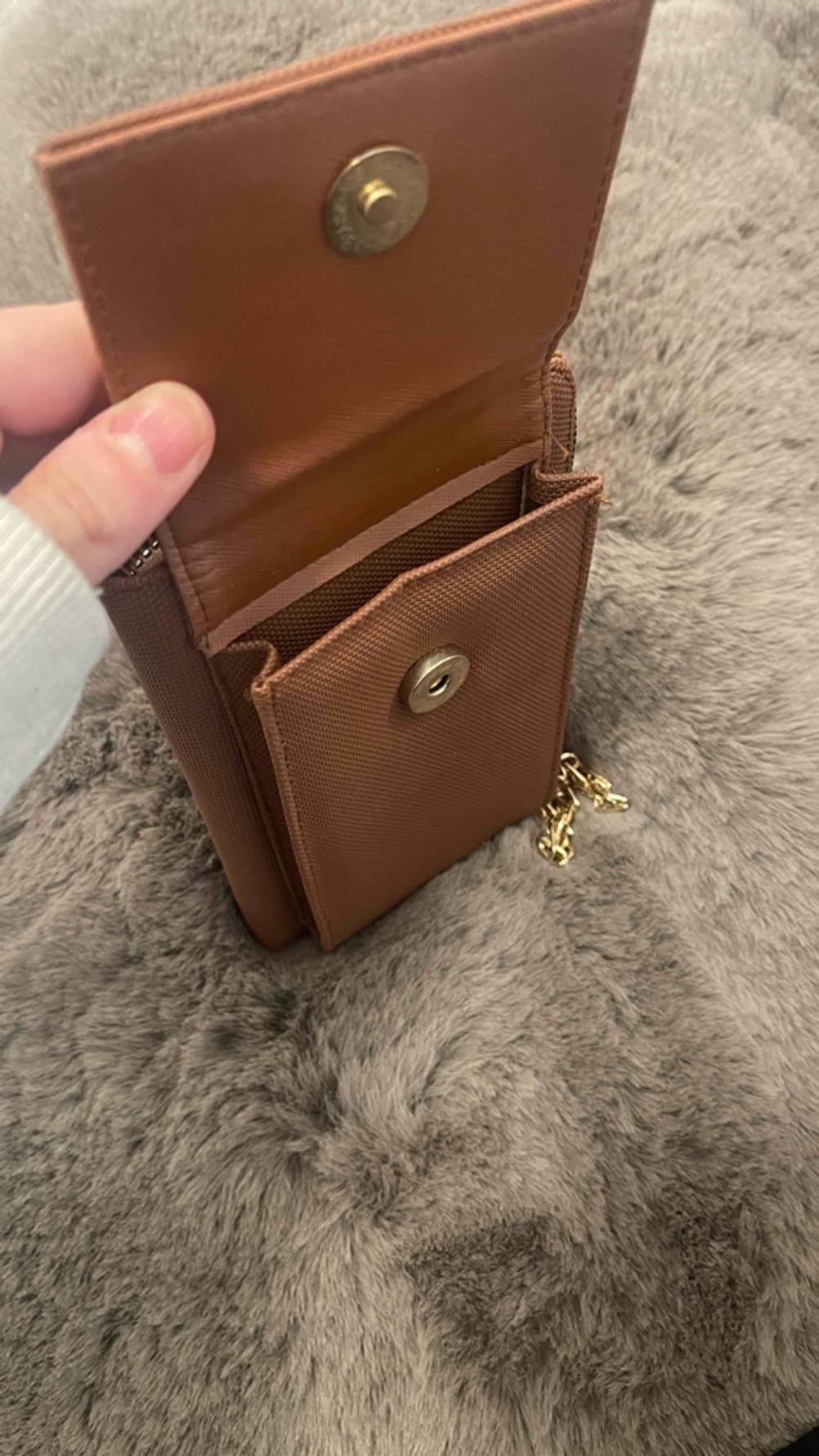 Eine Hand öffnet die getestete Handytasche.
