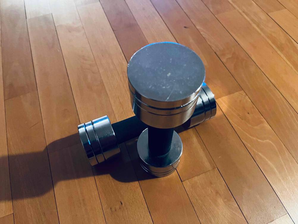 Hanteln-1-kg getestet: Eine liegende und eine stehende Hantel von oben auf einem Holzboden.