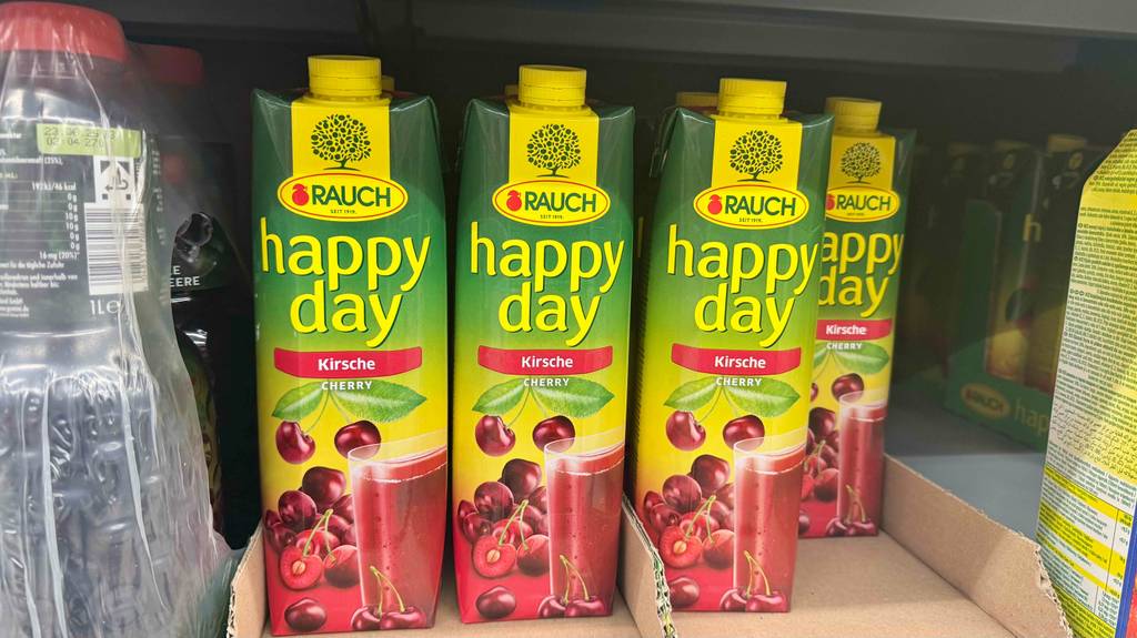 Happy Day Kirschsaft im Test: Mehrere Tetrapaks stehen auf einem Verkaufsregal.