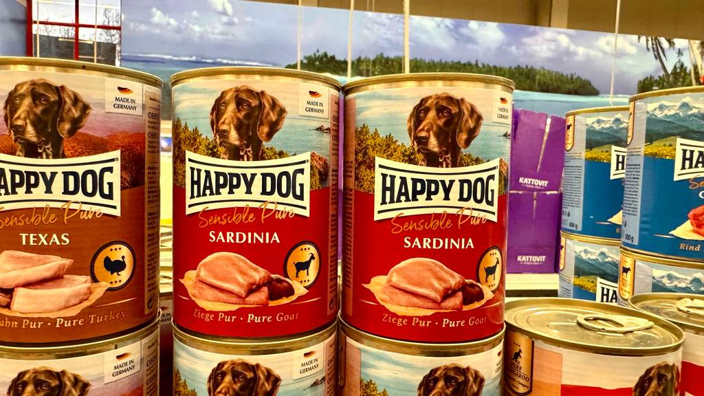Happy Dog-Nassfutter im Test: Mehrere Dosen stehen gestapelt in einem Regal.