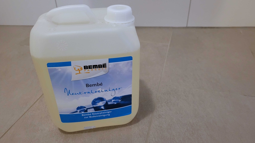 Ein Kanister eines getesteten Hartbodenreinigers auf einer Fliesenfläche von der Seite.