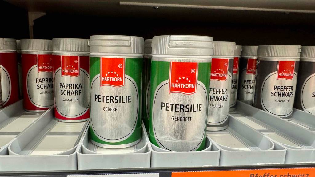 Petersilie im Test: Mehrere Dosen stehen zwischen anderen Gewürzen in einem Regal.