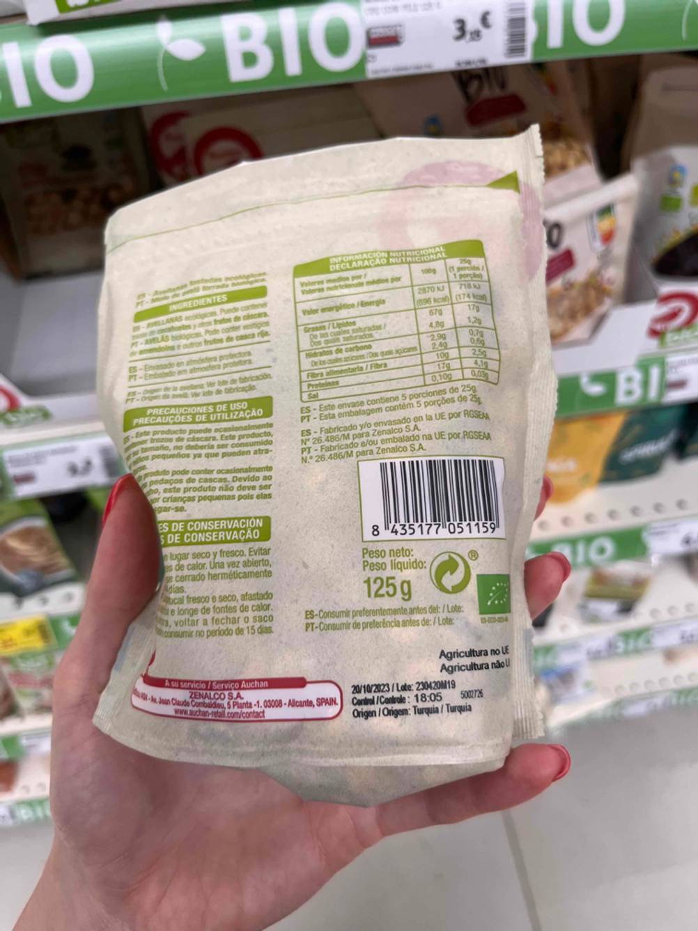 Eine Hand hält die Rückseite einer Packung der Haselnüsse im Test.