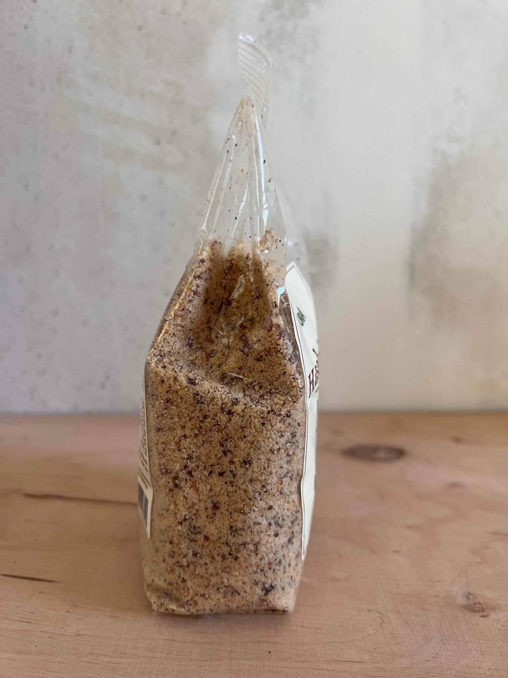 Mehrere Haselnüsse im Test: Gehackte Haselnüsse befindet sich verpackt auf einem Holztisch.
