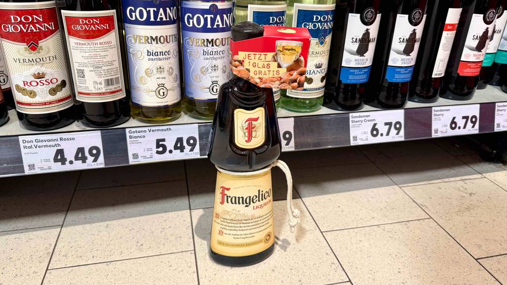 Vor eine Regal steht eine Flasche des Haselnusslikör i Test auf dem Boden.
