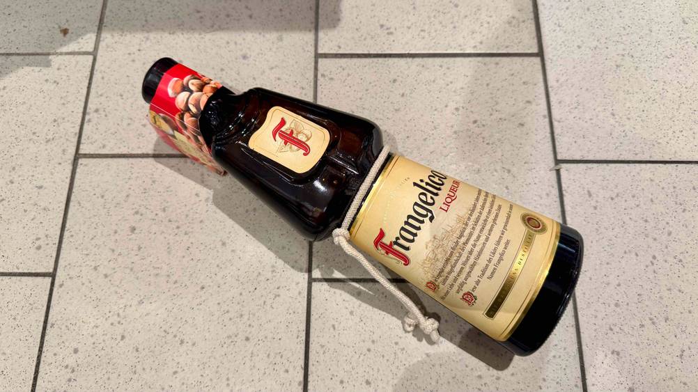 Eine Flasche des getesteten Haselnusslikörs liegt auf eine Fließenboden.