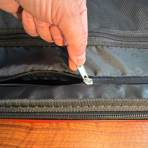 Das Innenfach vom Hauptstadtkoffer Mitte wird von einer Hand geschlossen.