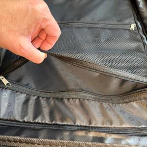 Eine Hand öffnet ein kleines Extrafach im Hauptstadtkoffer Mitte.