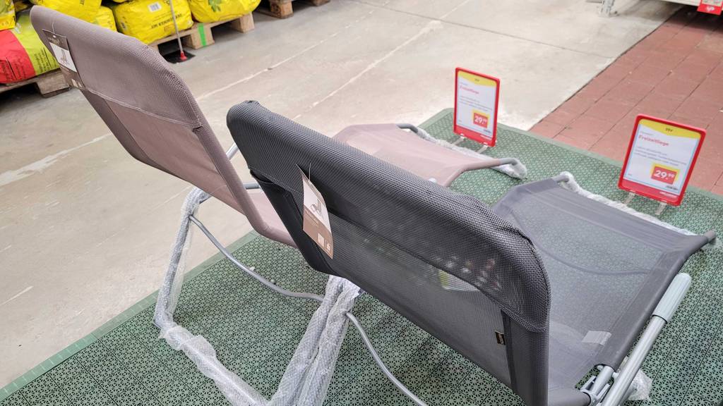 Ansicht von hinten auf einen altrosa und einen grauen getesteten Deckchair im Gartencenter.