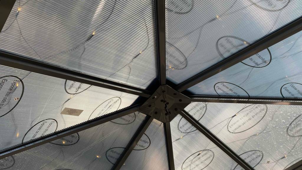 Pavillon-Metall-Test: Detailansicht von unten auf das Dach aus Polycarbonatplatten eines im Gartencenter aufgebauten Modells.