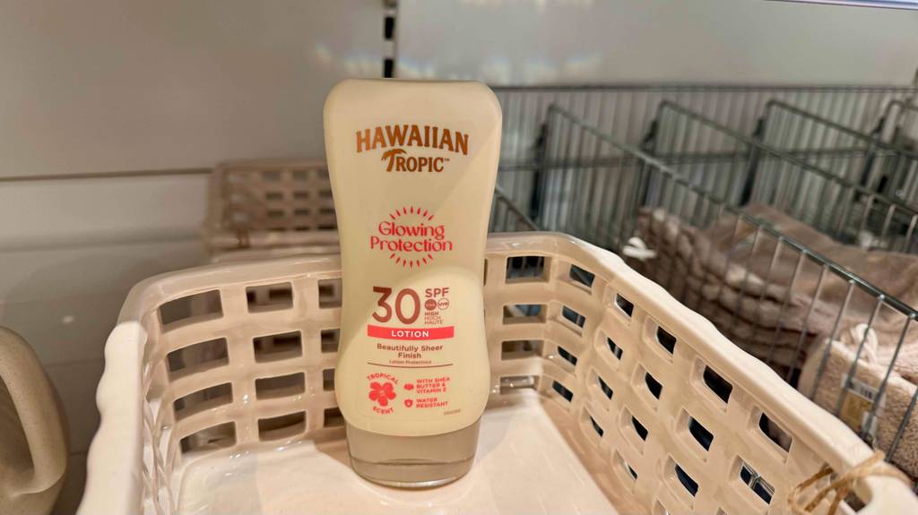 Eine Flasche getestete Hawaiian-Tropic-Sonnencreme steht in einem Wäschekorb.