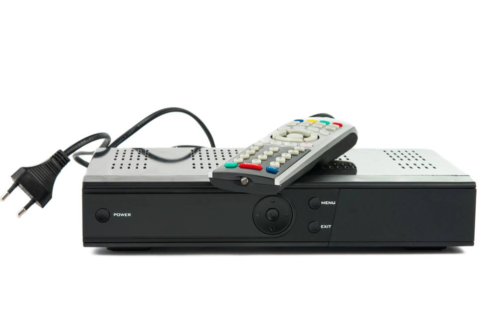 HD-Receiver im Test: kleines Gerät vor weißem Hintergrund mit Netzstecker und Fernbedienung.