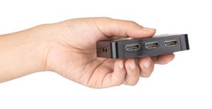 In Hand gehalene HDMI Switch vor weissem Hintergrund.