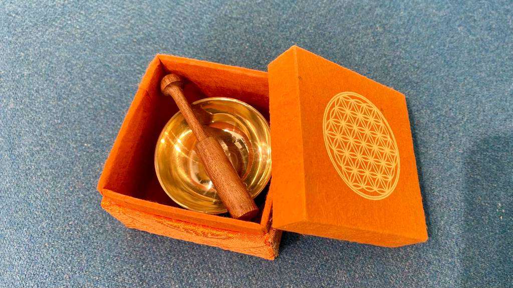 Eine getestete Klangschale in ihrer orangenen Kiste mit mit ihrem Klöppel.