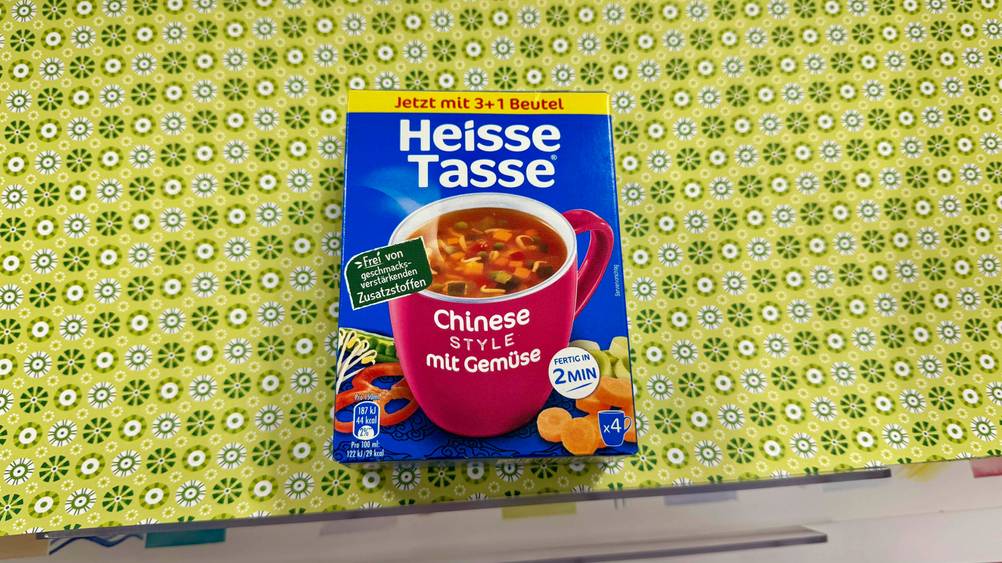 Eine Packung der getesteten Heisse Tasse liegt auf einem gelben Untergrund.