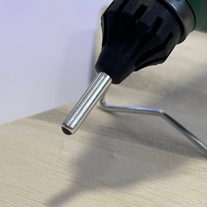 Detailansicht der langen Düse der Bosch PKP 18 E Heißklebepistole auf heller Oberfläche mit Standfuß