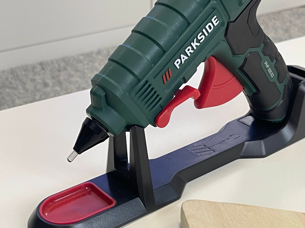 Parkside Heißklebepistole in Dockingstation, Nahaufnahme mit roter Abzugsvorrichtung