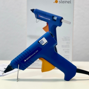 Steinel Gluematic 3002 steht auf weißem Untergrund vor Originalverpackung