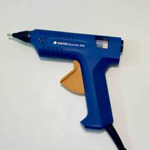 Die blaue Steinel Gluematic 3002 liegt quer auf einem weißen Tisch.