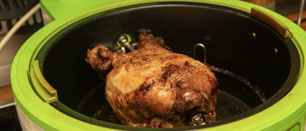 Heißluftfritteuse mit Drehkorb im Test: Ein Hähnchen wird am Spieß zubereitet.