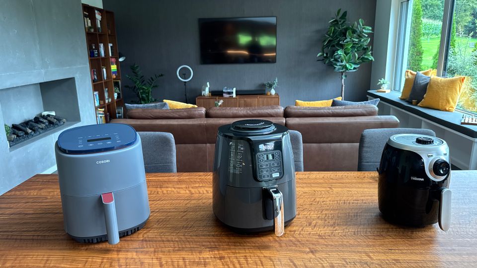 Drei Heißluftfritteusen stehen nebeneinander auf einem Tisch.