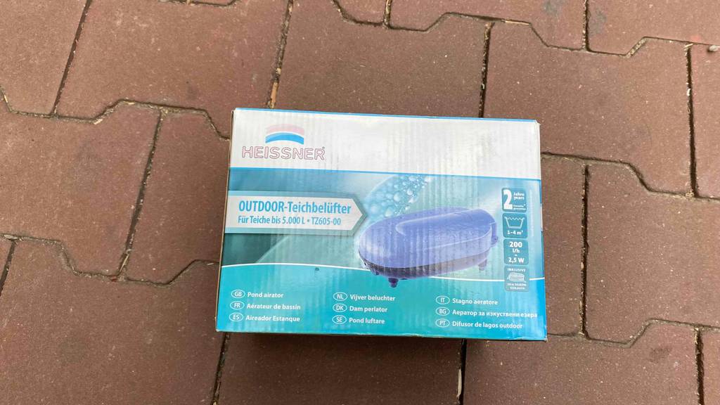 Teichbelüfter-Test: Verpackung des Belüfters liegt auf Steinuntergrund.