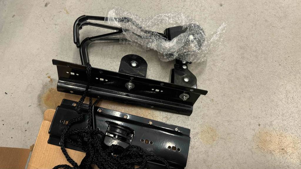 Ein Fahrradlift liegt halb ausgepackt zum Testen auf einem Boden.