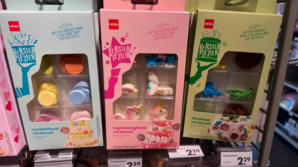 Mehrere Packungen Einhorn-Tortendeko hängen hintereinander zum testen zwischen anderen Varianten.