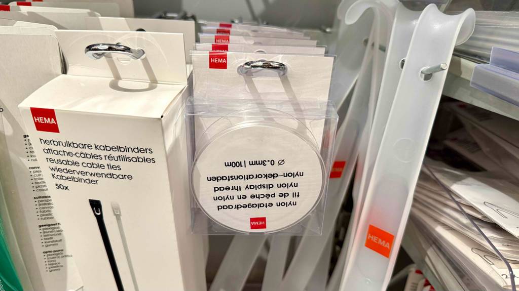 Mehrere Nylonfaden hängen in transparenter Verpackung zum testen zwischen anderen Produkten in einem Hängeregal.