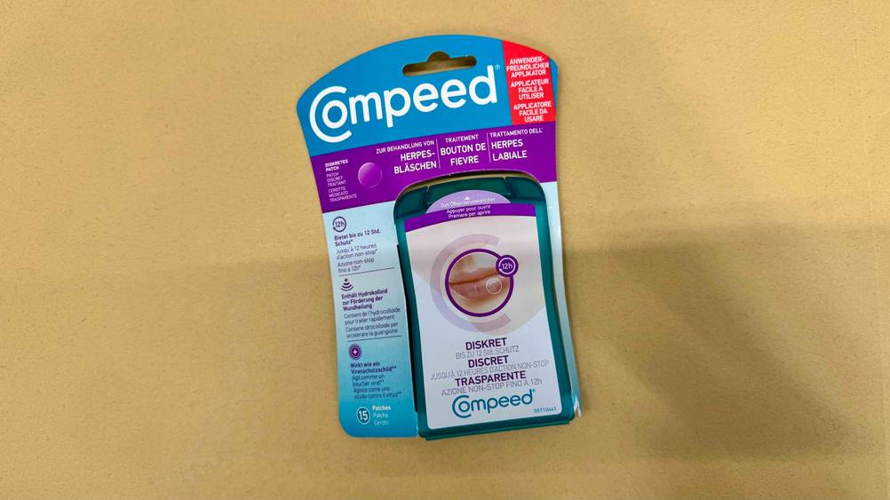 Getestet: Eine Packung Herpes-Mittel liegt auf einer gelben Fläche.