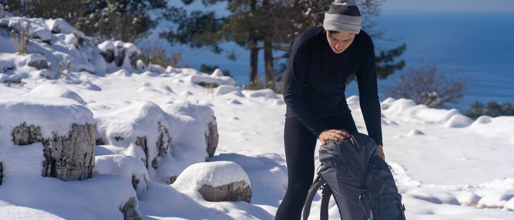 Merino-Shirt-Test: Ein Mann mit Wanderrucksack und Mütze im Schnee.