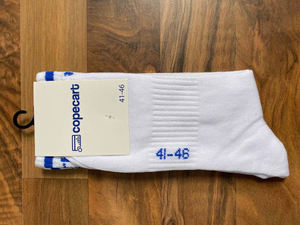 Im Test: Ein Paar Herrensocken verpackt auf einer Holzfläche.