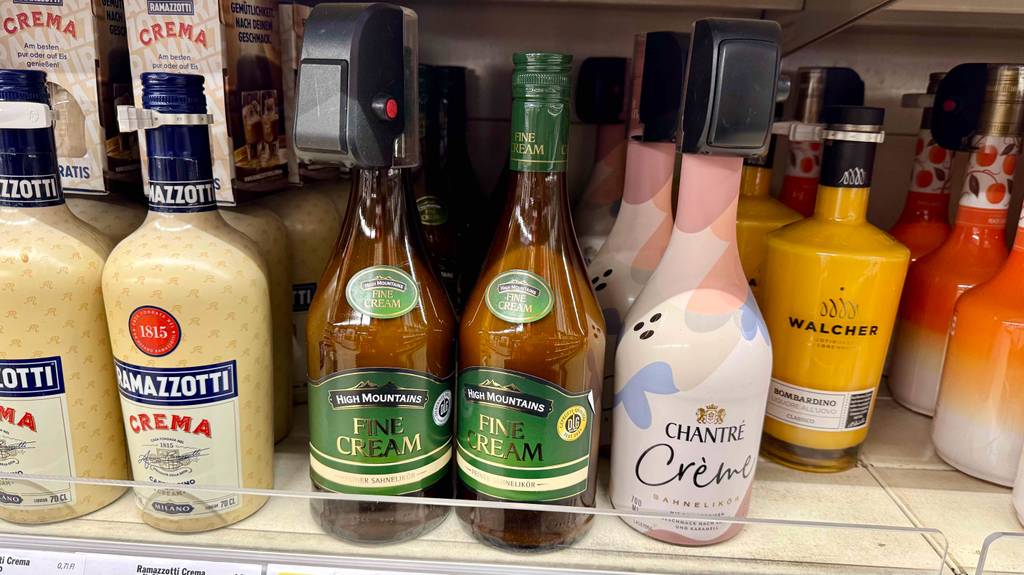 Eine Flasche inklusive getestetem Sahnelikör steht auf einem Verkaufsregal neben weiteren Likörsorten mit Sahne.
