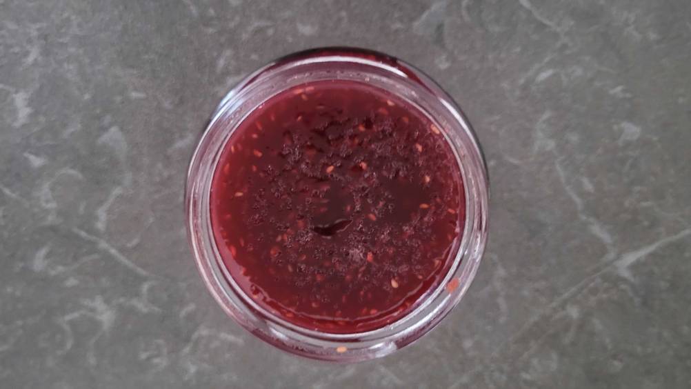 Im Test: Nahaufnahme der Himbeermarmelade im Glas von oben.