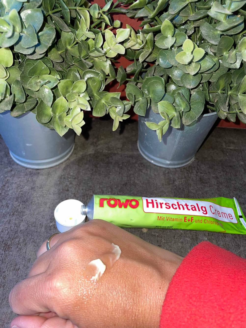 Auf einer Hand befindet sich einiges der getesteten Hirschtalgcreme die im Hintergrund liegt.